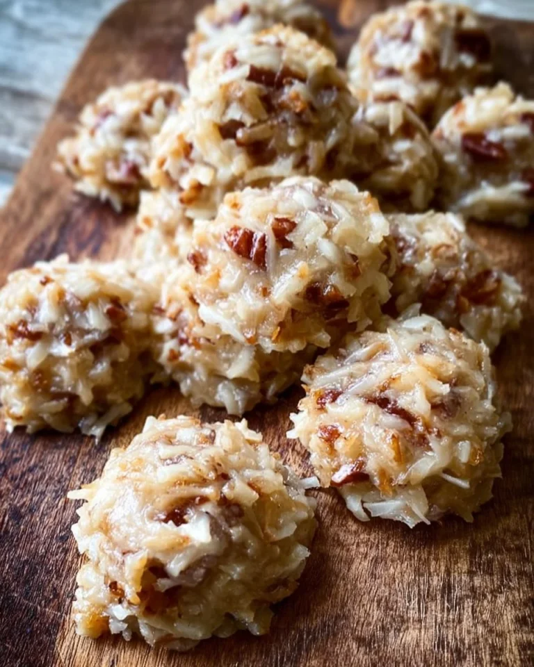 No bake coconut praline cookies on a plate, topped with coconut flakes.