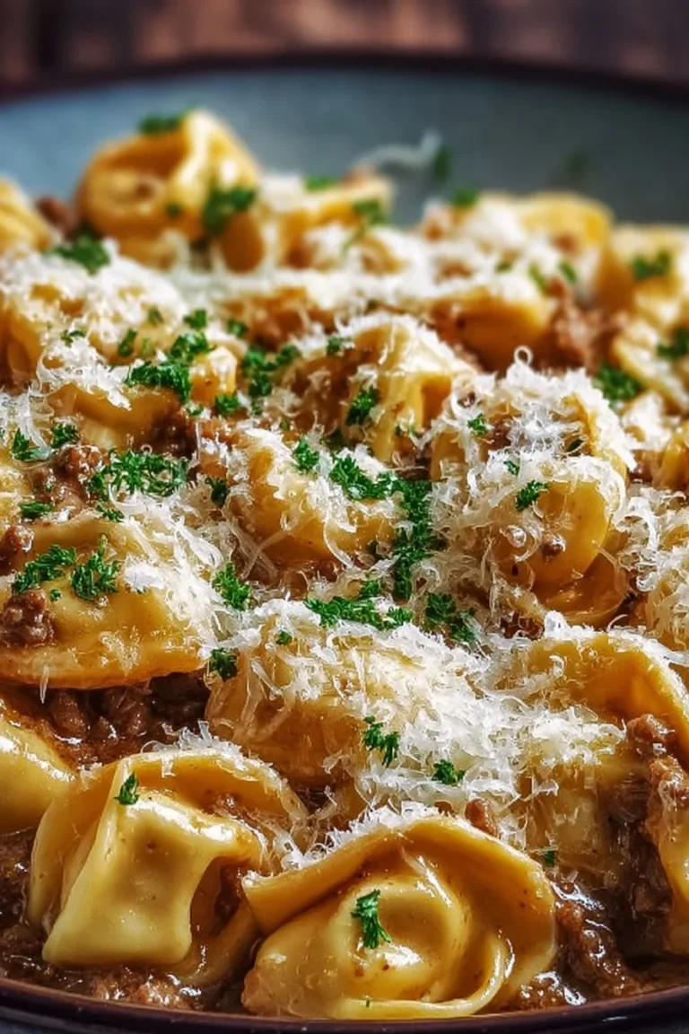 Creamy beef tortellini dish topped with Parmesan cheese