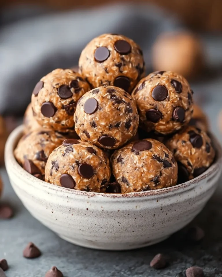 No bake chocolate chip cookie balls on a white plate, topped with chocolate chips.