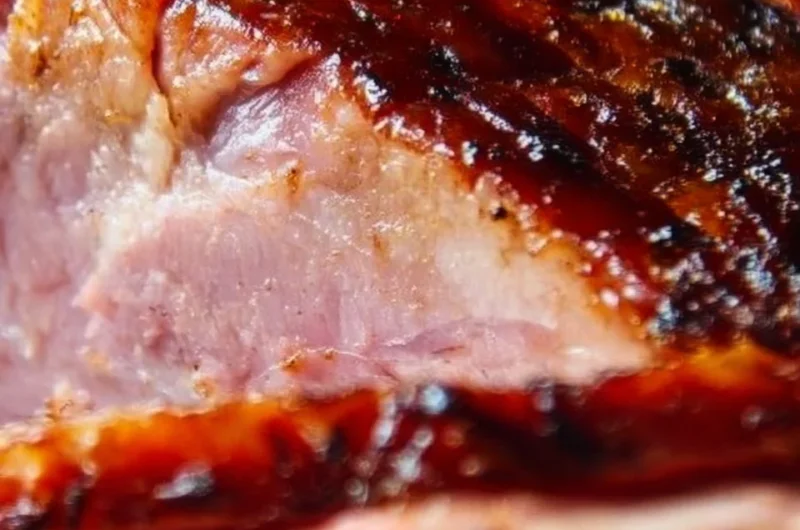 Delicious brown sugar glazed ham served on a festive table.