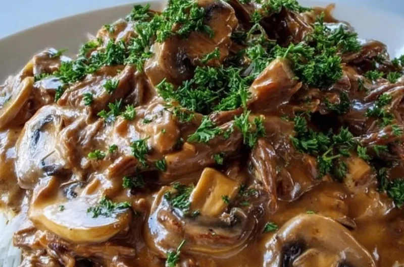 Creamy slow cooker beef stroganoff served with noodles and parsley