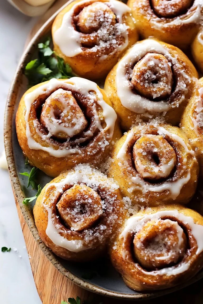 Freshly baked apple cider cinnamon rolls topped with icing