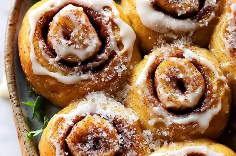 Freshly baked apple cider cinnamon rolls topped with icing