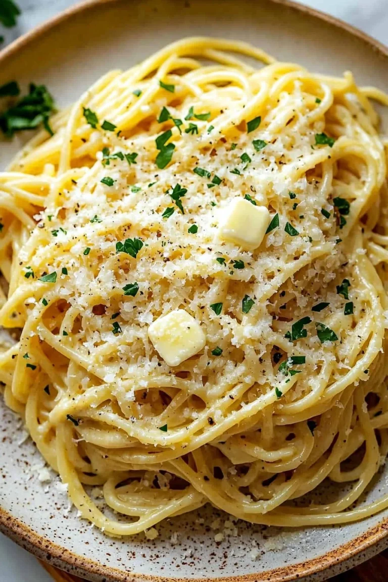 Plate of buttery garlic noodles with Parmesan cheese sprinkled on top