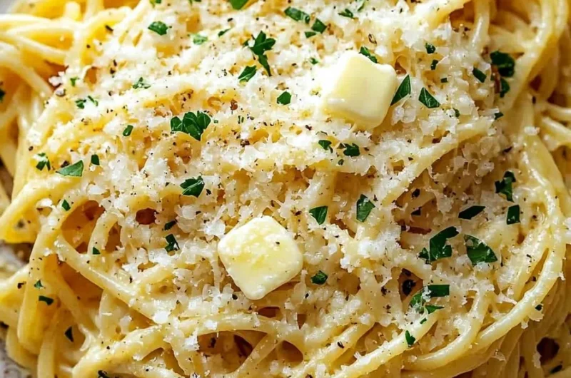 Plate of buttery garlic noodles with Parmesan cheese sprinkled on top