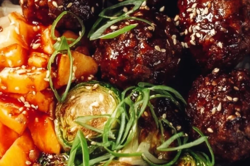 Warm and hearty Korean meatball bowl topped with fresh vegetables and sauce.