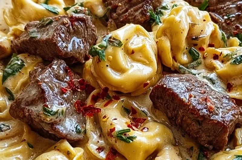 Plate of garlic steak tortellini in creamy sauce topped with cracked garlic