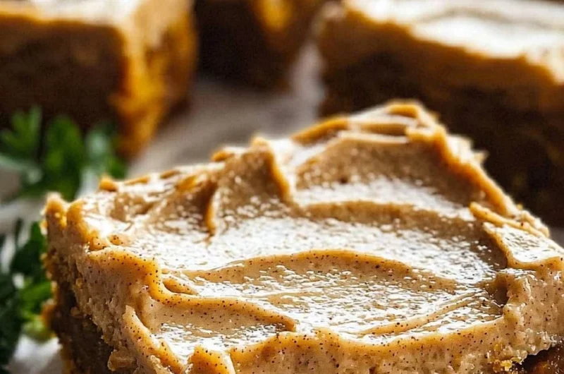 Delicious pumpkin bars with brown sugar frosting on a rustic wooden table