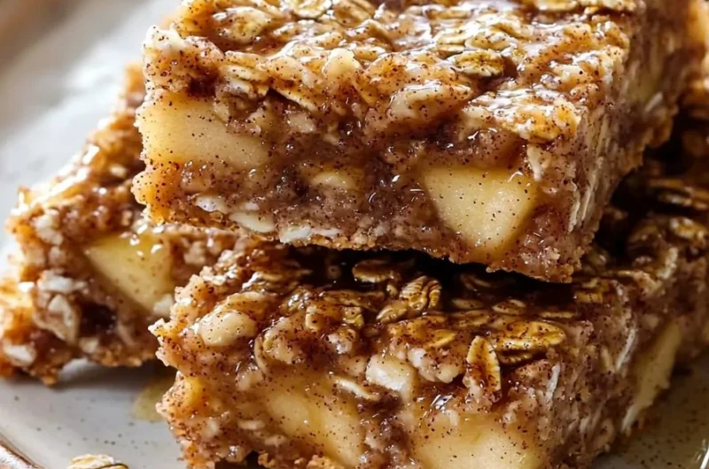 Chewy apple cinnamon breakfast bars on a wooden table, ready to eat.