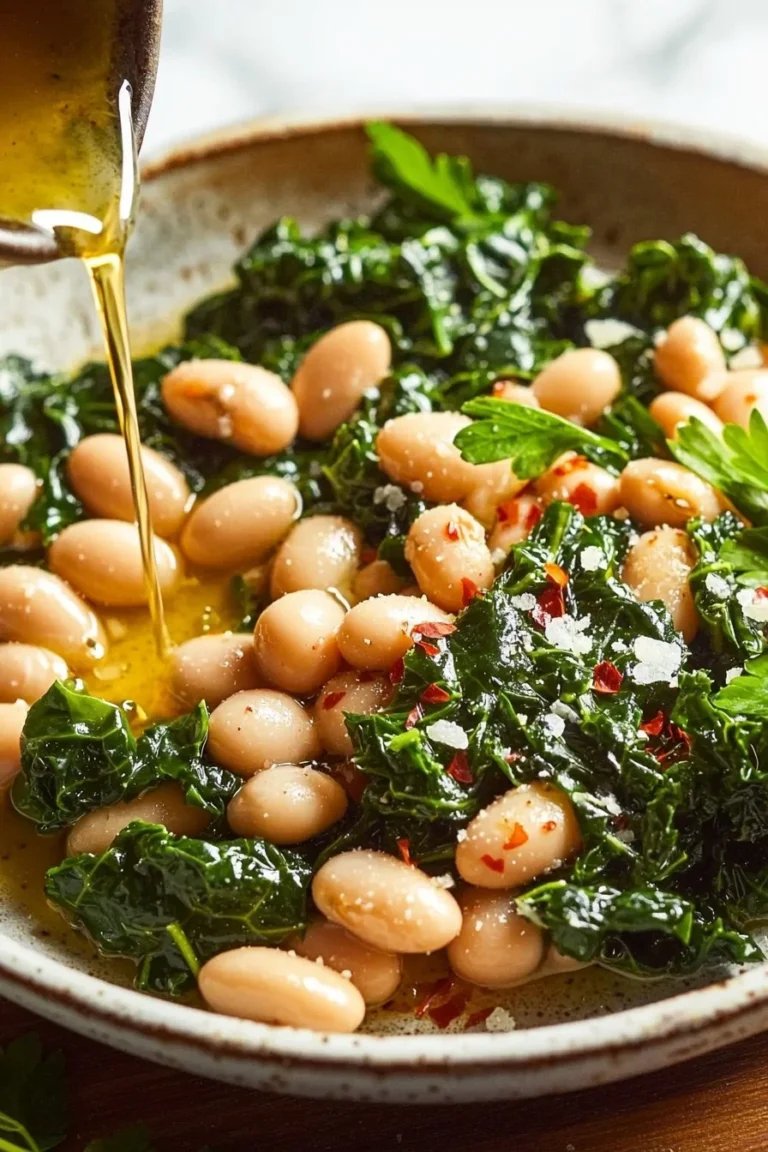 Bowl of easy Mediterranean white beans and greens, garnished with herbs