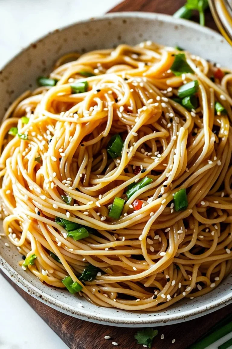 Bowl of quick and easy Asian Sesame Noodles garnished with sesame seeds and green onions.