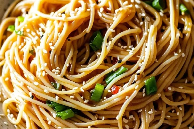 Bowl of quick and easy Asian Sesame Noodles garnished with sesame seeds and green onions.