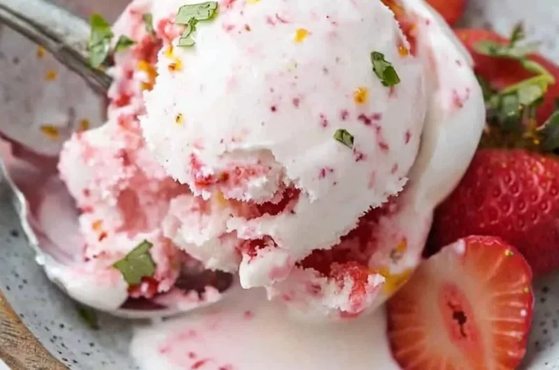 Bowl of easy Greek yogurt strawberry ice cream topped with fresh strawberries