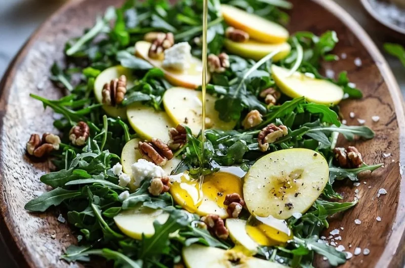 Fresh apple arugula salad with vibrant ingredients on a wooden table